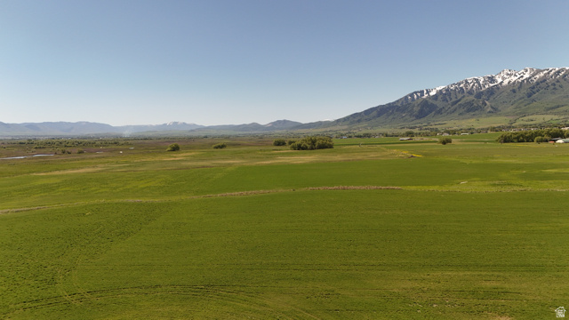 320 South 5400 West Logan, UT 84321 - Photo 35 of 42 Expansive agricultural fields with distant snow-capped mountains under a clear sky