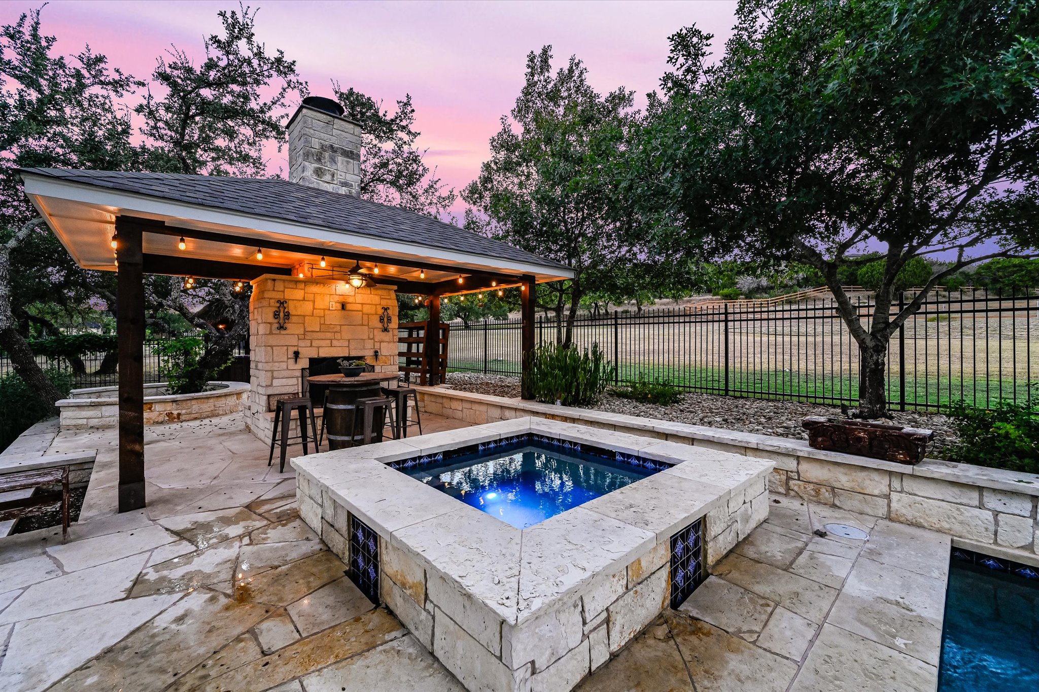 786 Ranchers Club Lane Driftwood, TX 78619 - Photo 28 of 33 Pool at dusk featuring a patio, a fenced backyard, and an in-ground hot tub