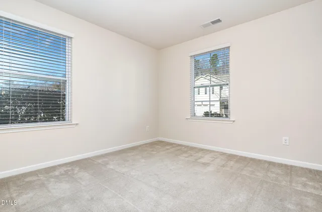 an empty room with a ceiling fan and window