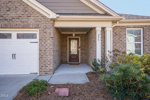 an empty room with wooden floor mirror and windows