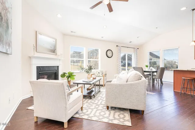 a large kitchen with cabinets wooden floor table and chairs