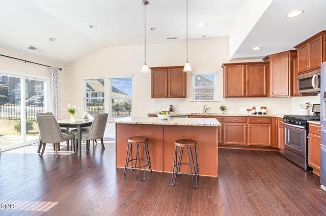 a kitchen with stainless steel appliances granite countertop a sink a stove and a refrigerator
