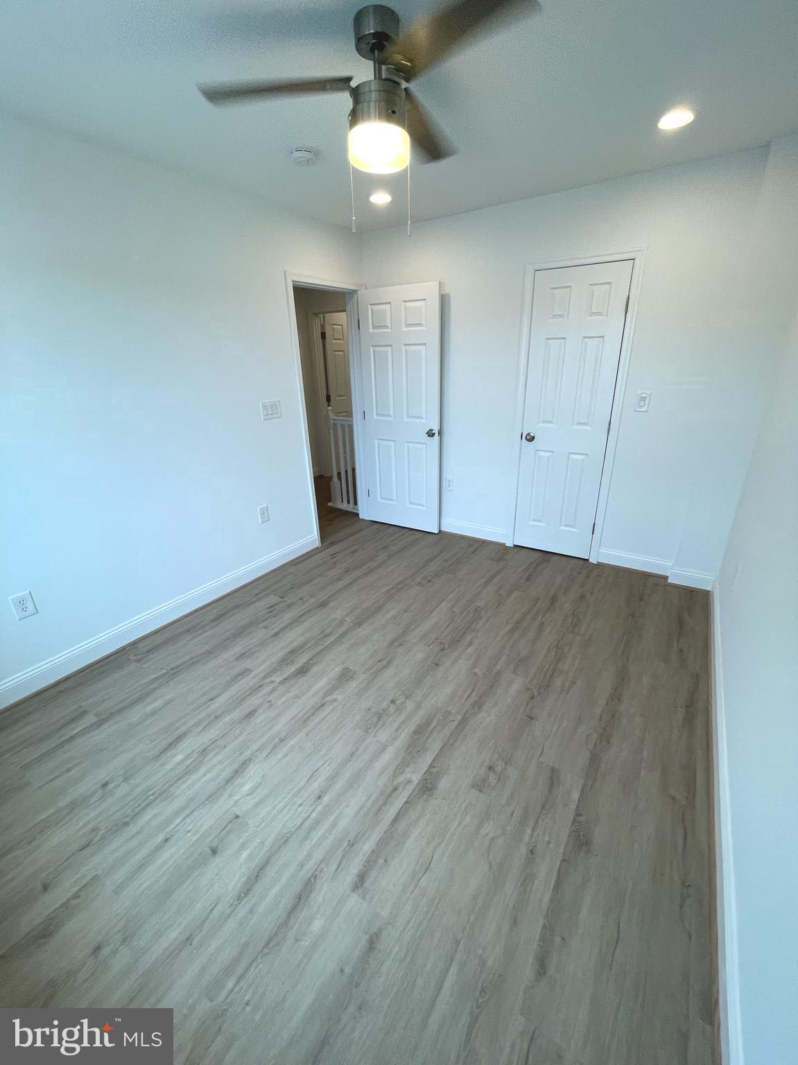 1718 Lang Place Northeast Washington, DC 20002 - Photo 15 of 32 an empty room with wooden floor a ceiling fan and entryway