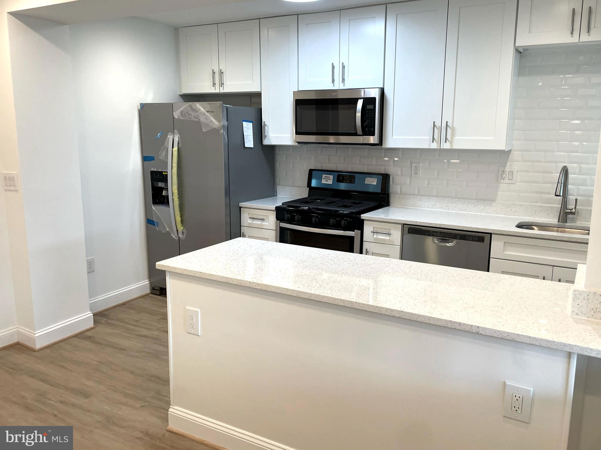 1718 Lang Place Northeast Washington, DC 20002 - Photo 8 of 32 a kitchen with stainless steel appliances a refrigerator a stove top oven a sink and dishwasher