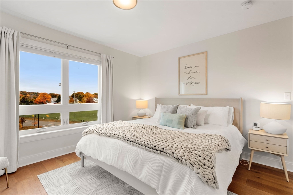 3 Bennett Street, Unit 402 Wakefield, MA 01880 - Photo 13 of 23 a bedroom with a bed a dresser and a large window