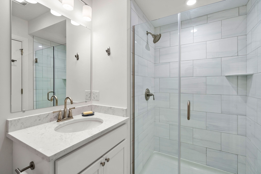 3 Bennett Street, Unit 402 Wakefield, MA 01880 - Photo 15 of 23 a bathroom with a sink shower and a mirror