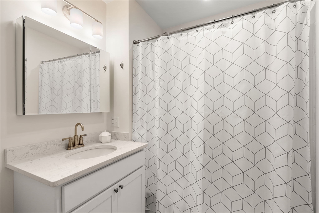 3 Bennett Street, Unit 402 Wakefield, MA 01880 - Photo 18 of 23 a bathroom with a sink and a mirror