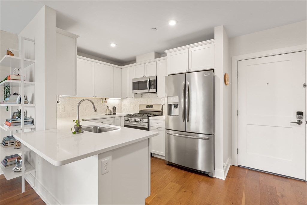 3 Bennett Street, Unit 402 Wakefield, MA 01880 - Photo 3 of 23 a kitchen with appliances a refrigerator and a sink