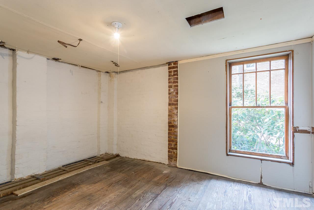 2276 The Circle Raleigh, NC 27608 - Photo 16 of 25 an empty room with wooden floor and windows