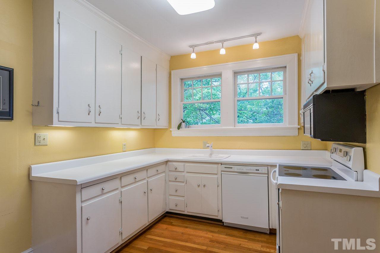 2276 The Circle Raleigh, NC 27608 - Photo 4 of 25 a view of a kitchen with a sink and dishwasher next to a window
