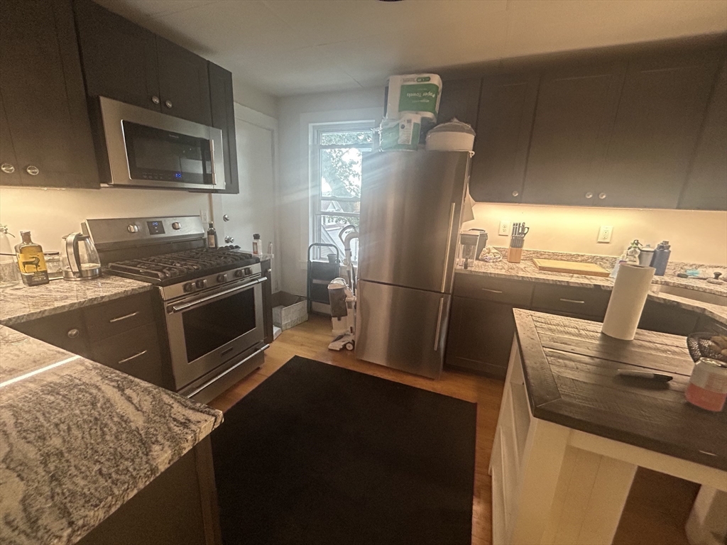 12 Pearl St Place, Unit 3 Somerville, MA 02145 - Photo 8 of 12 a kitchen with a sink stove and refrigerator