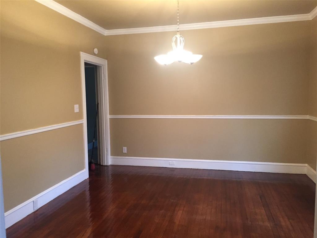 313 Merrick Street Shreveport, LA 71104 - Photo 8 of 18 an empty room with wooden floor and chandelier