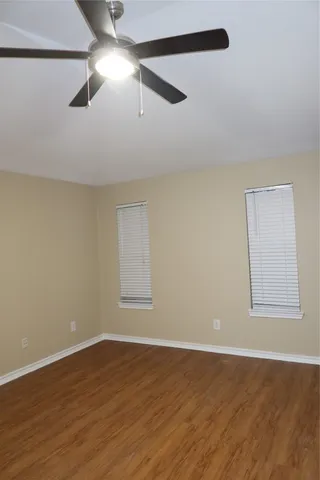 a view of empty room with wooden floor and fireplace