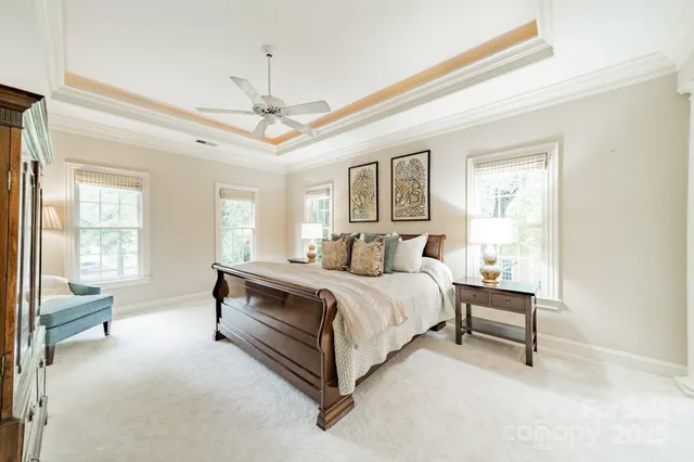 a spacious bedroom with a bed a chandelier and a window