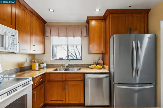a kitchen with stainless steel appliances granite countertop a refrigerator sink and cabinets