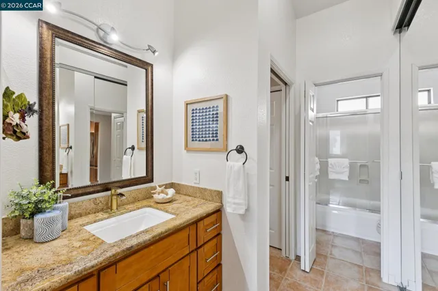 a bathroom with a granite countertop sink and a mirror