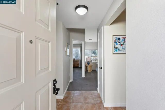 a view of a hallway with a livingroom and a bathroom