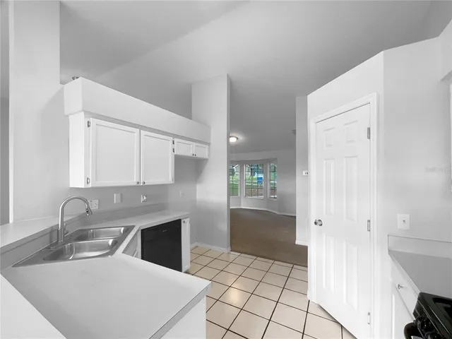 a kitchen with stainless steel appliances kitchen island granite countertop a refrigerator and a sink