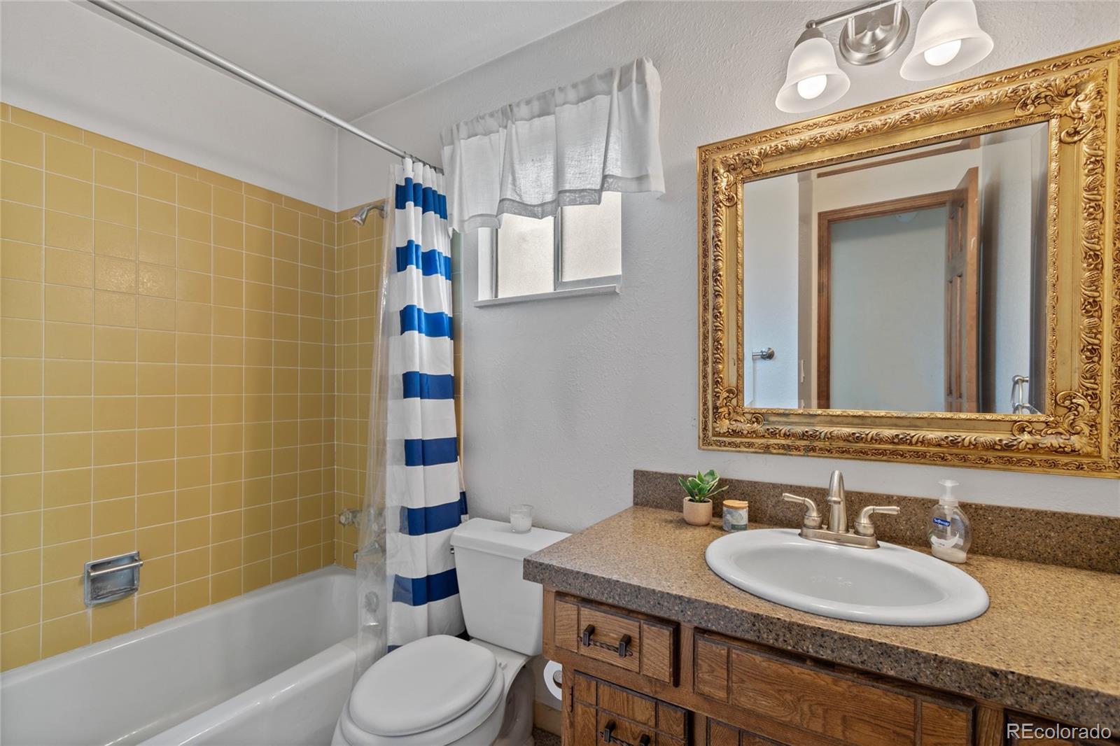 3315 Marshall Street Wheat Ridge, CO 80033 - Photo 13 of 30 a bathroom with a sink a toilet and shower