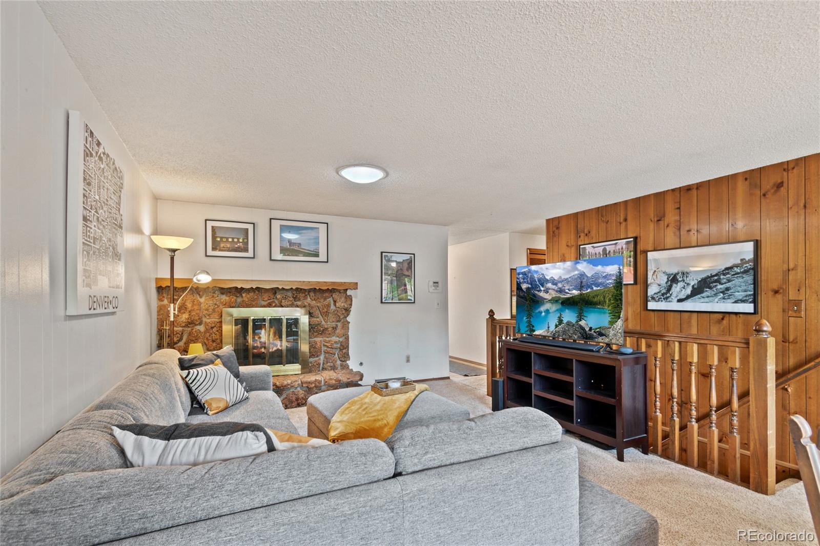3315 Marshall Street Wheat Ridge, CO 80033 - Photo 7 of 30 a living room with furniture a flat screen tv and a fireplace