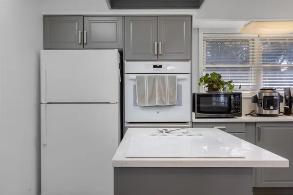a white kitchen with a sink and refrigerator