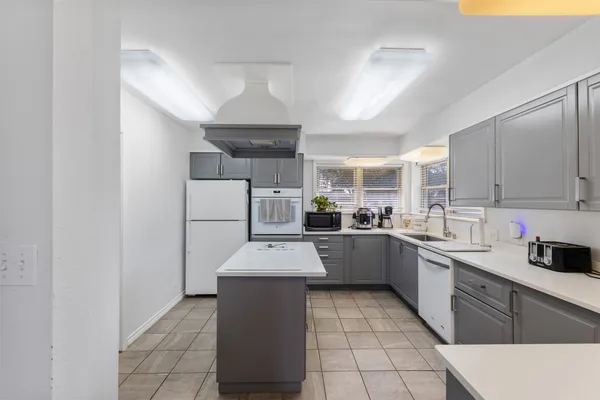 a kitchen with a sink a counter top space stainless steel appliances and cabinets