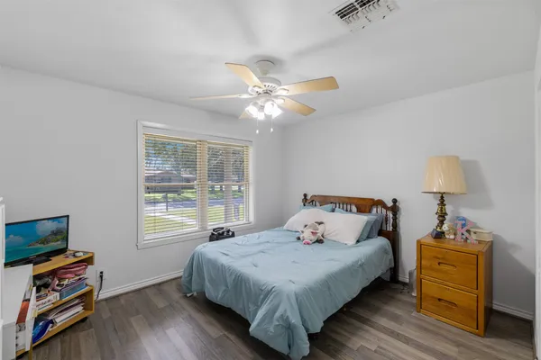 a bedroom with a bed and a flat tv screen on a dresser