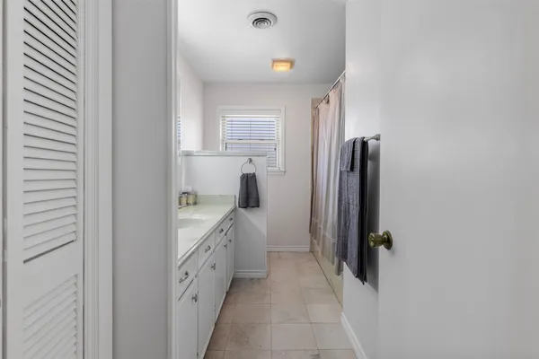 a bathroom with a double vanity sink a vanity and a bathtub