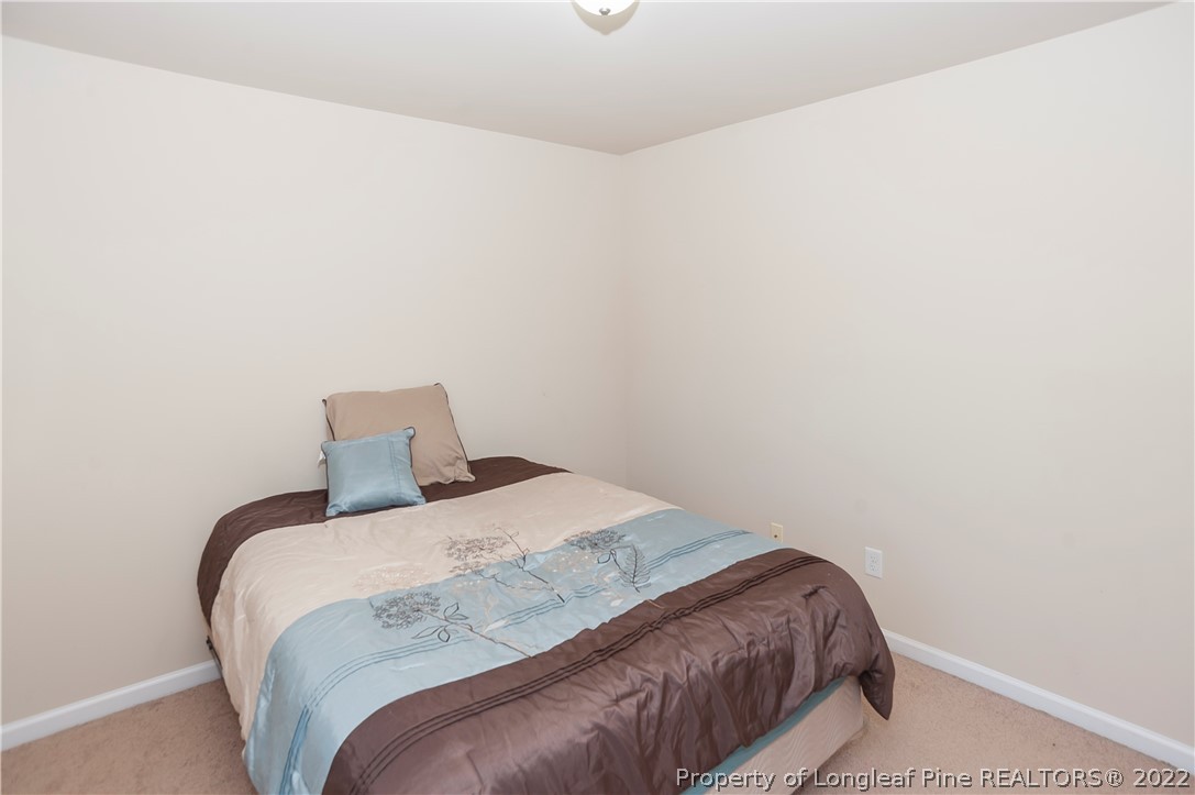4980 Aberdeen Road Raeford, NC 28376 - Photo 32 of 38 a bedroom with a bed and a lamp