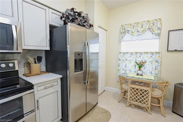 a kitchen with stainless steel appliances a refrigerator sink and white cabinets