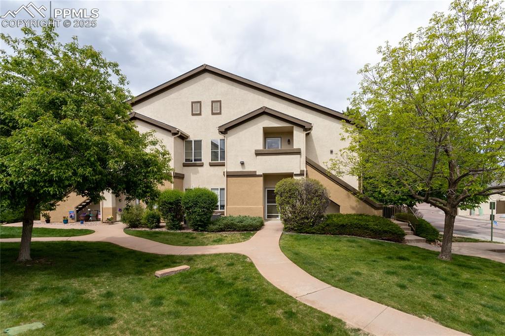 3815 Riviera Grove, Unit 201 Colorado Springs, CO 80922 - Photo 2 of 31 a front view of a house with a yard