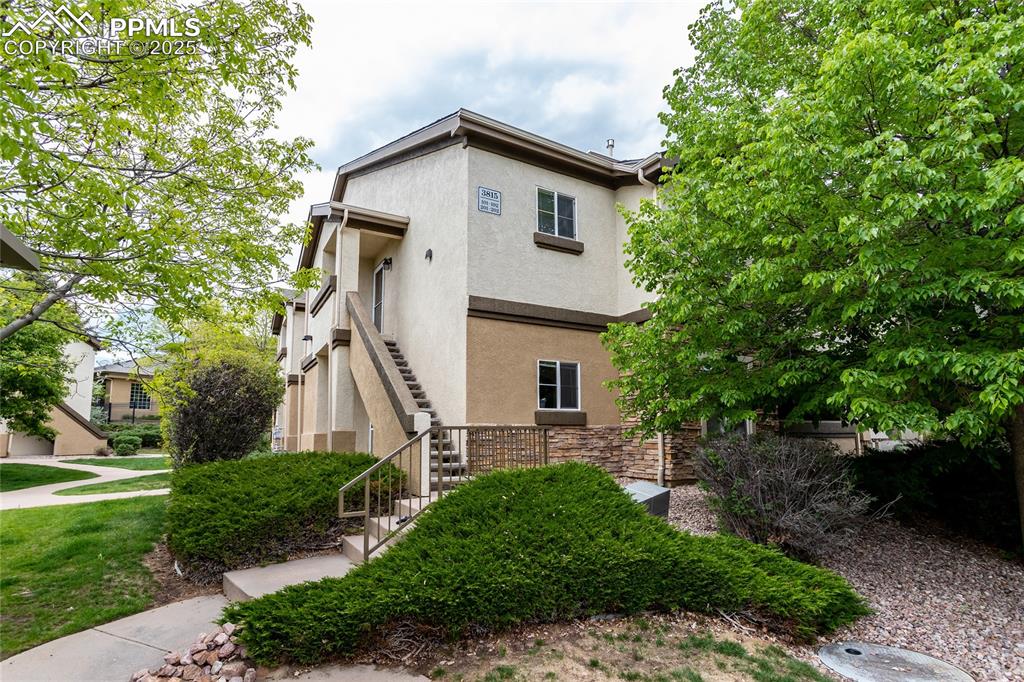 3815 Riviera Grove, Unit 201 Colorado Springs, CO 80922 - Photo 29 of 31 a front view of a house with a yard and trees