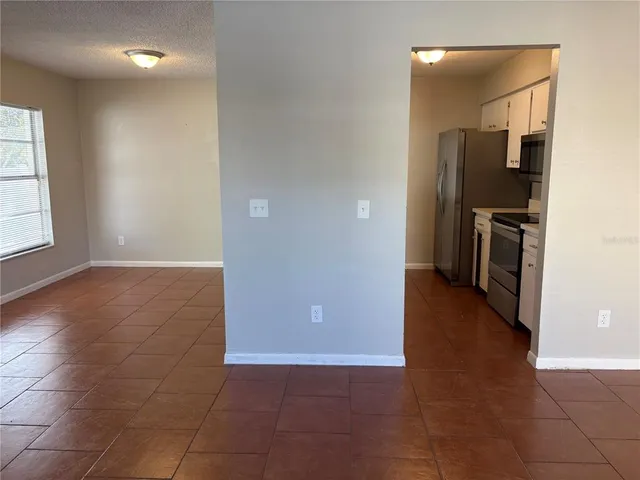 an empty room with kitchen and a window