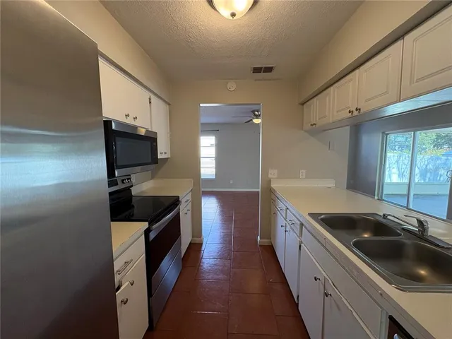 a kitchen with granite countertop a sink and a stove top oven