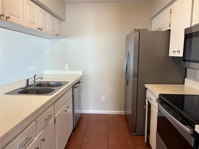 a kitchen with stainless steel appliances a sink stove and refrigerator