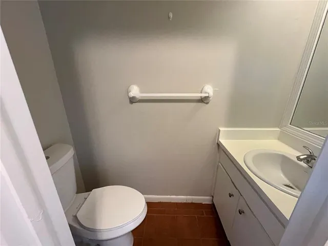 a bathroom with a granite countertop toilet and a sink