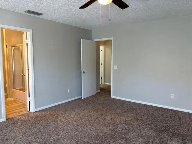 an empty room with chandelier fan