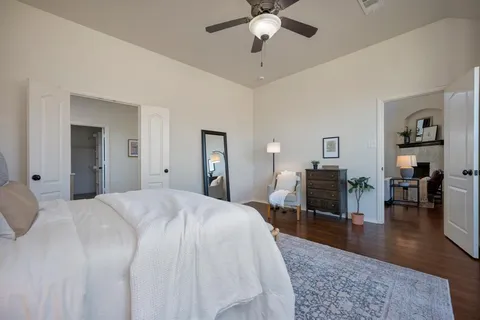 a spacious bedroom with a bed and a chandelier