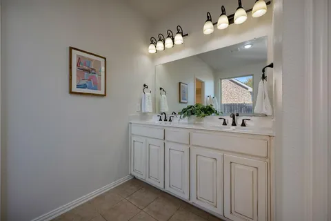 a bathroom with a double vanity sink and a mirror