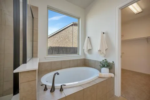 a bath tub sitting in a bathroom next to a window
