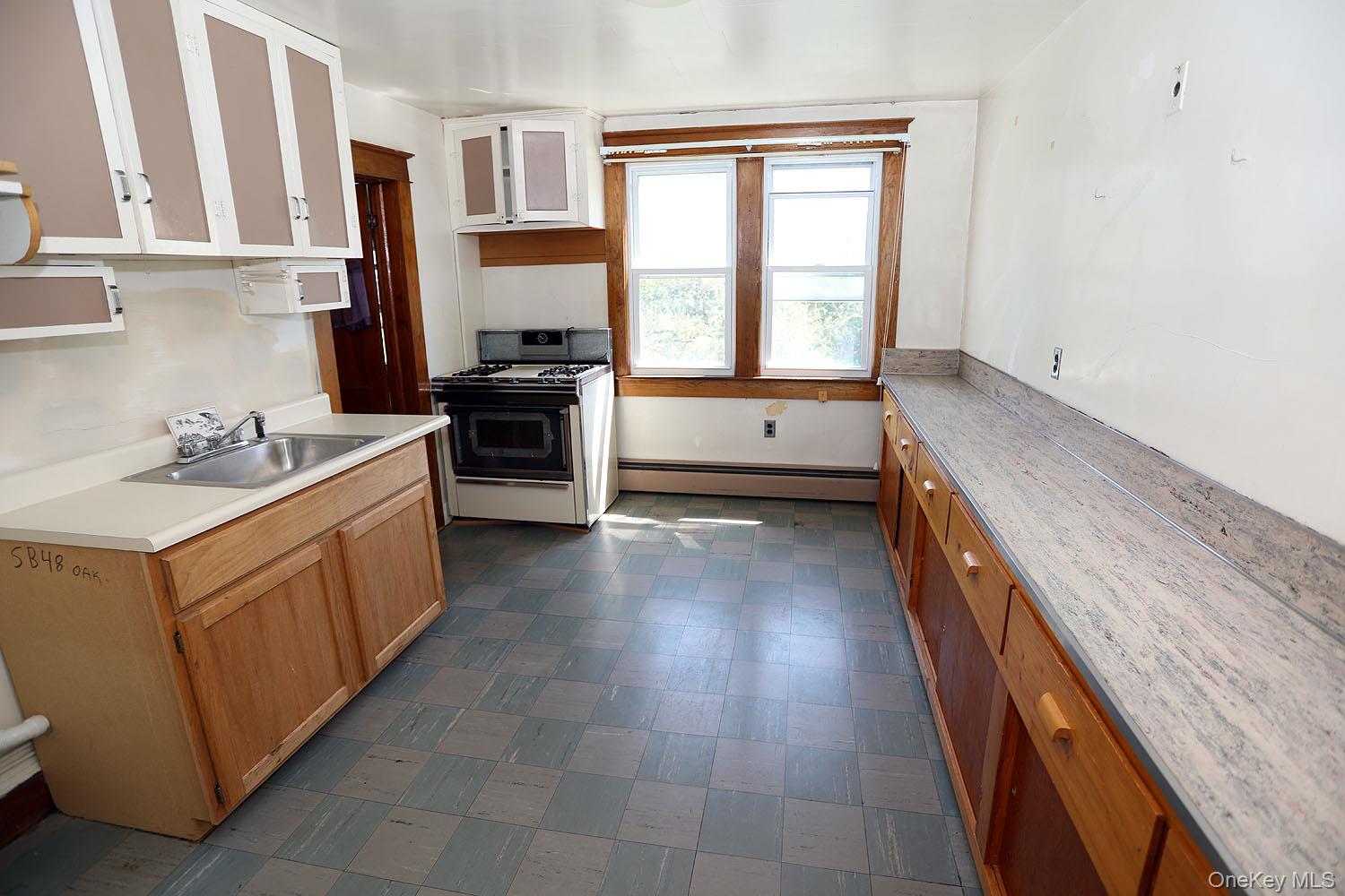 1779 Shandelee Road Livingston Manor, NY 12758 - Photo 18 of 31 a kitchen with a stove a sink and a refrigerator