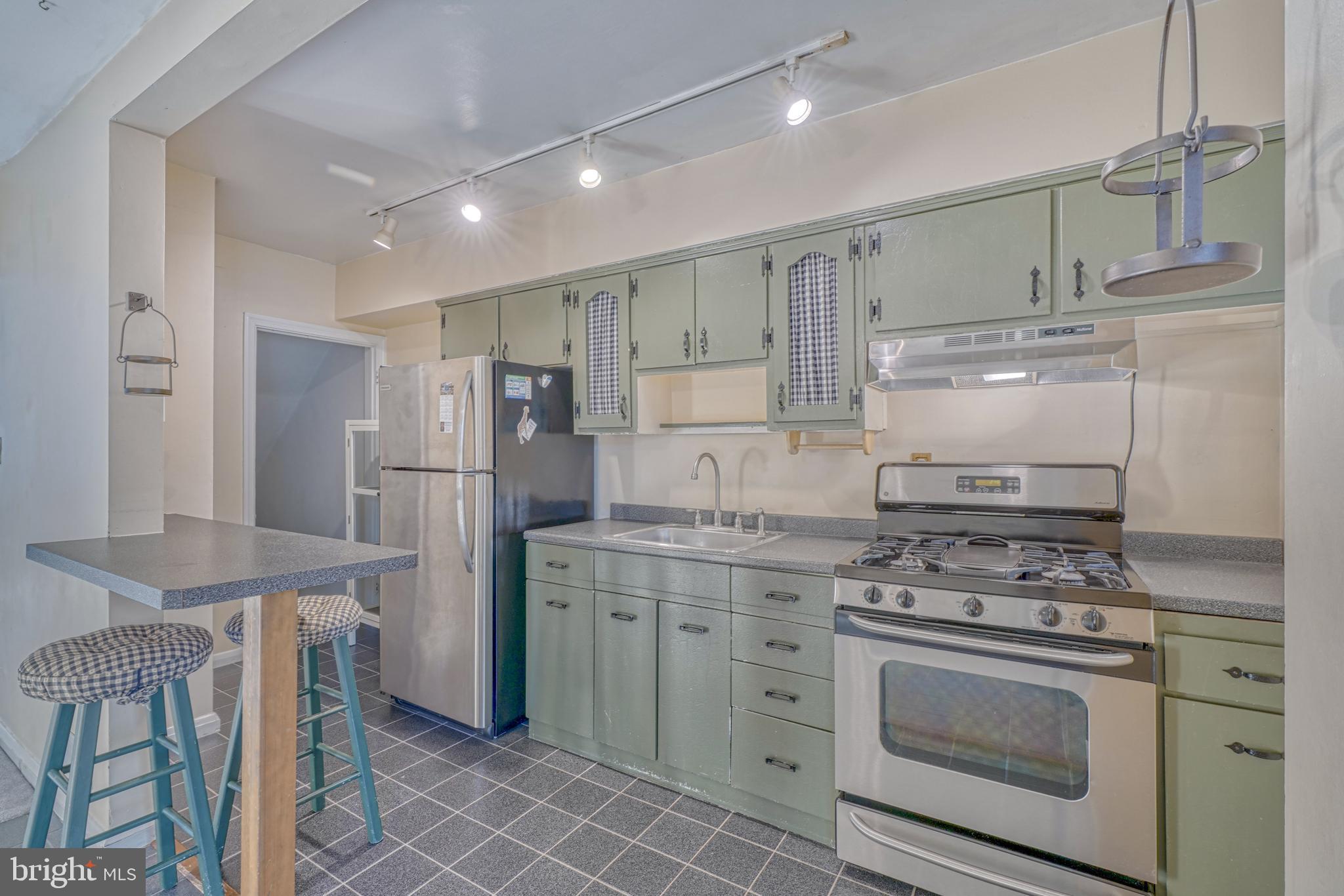 8324 Ridgely Oak Road Parkville, MD 21234 - Photo 11 of 25 a kitchen with stainless steel appliances granite countertop a stove a refrigerator and a cabinets