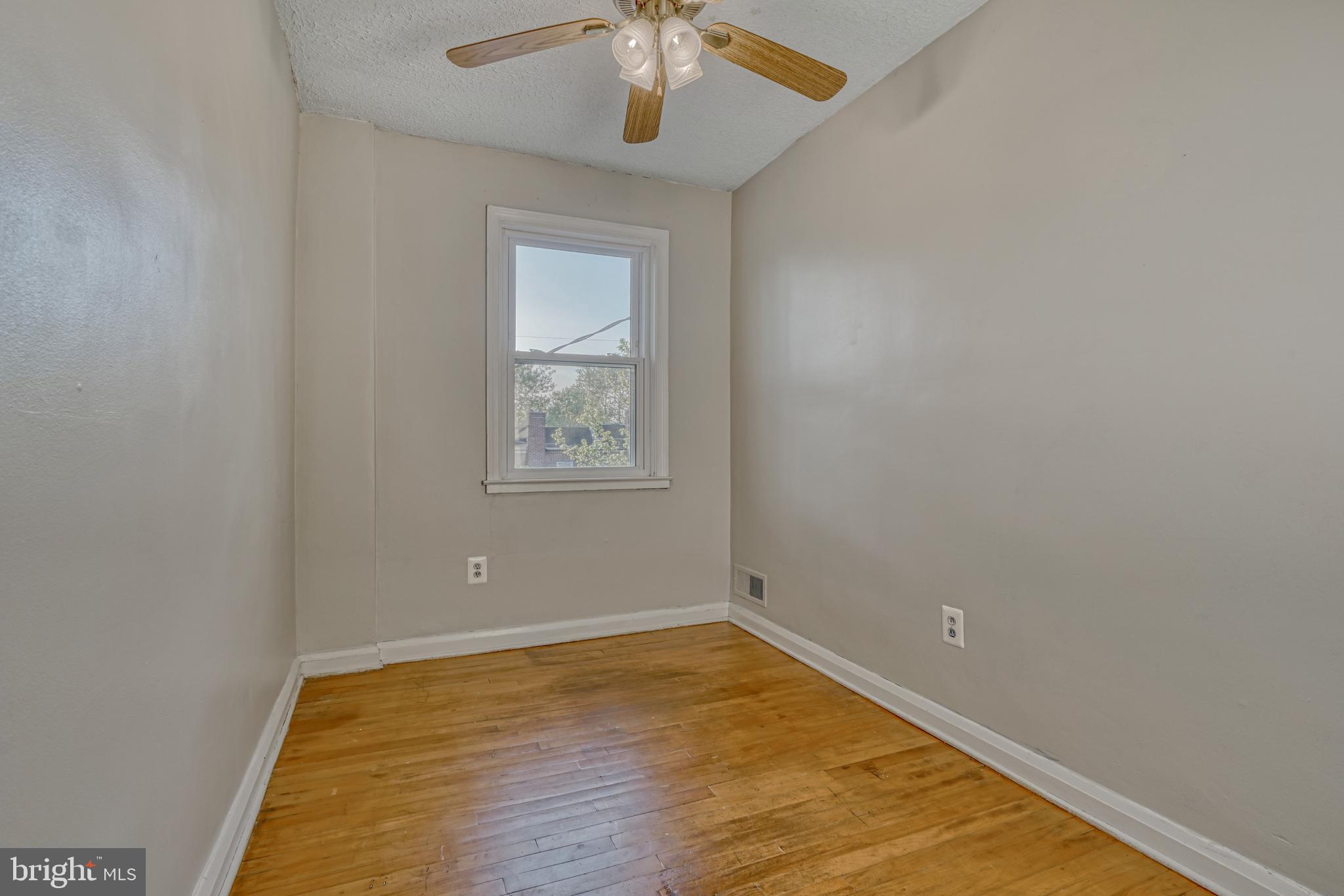 8324 Ridgely Oak Road Parkville, MD 21234 - Photo 19 of 25 wooden floor in an empty room with a window
