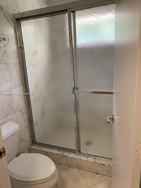 4450 Jog Road Greenacres, FL 33467 - Photo 12 of 18 a white toilet sitting next to a shower