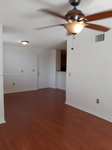 a view of an empty room with a chandelier fan