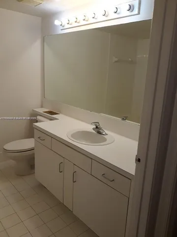 a bathroom with a sink and mirror with toilet