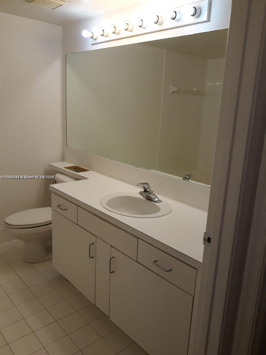 2123 Renaissance Boulevard, Unit 207 Miramar, FL 33025 - Photo 9 of 14 a bathroom with a sink and mirror with toilet