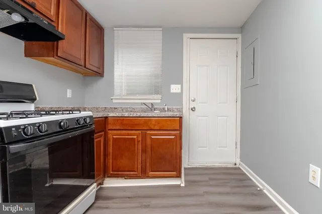 a kitchen with granite countertop wooden cabinets and stainless steel appliances