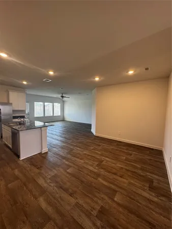 a view of kitchen with kitchen island granite countertop a stove top oven and a sink