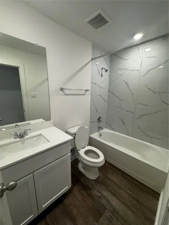 a bathroom with a sink toilet a mirror and bathtub